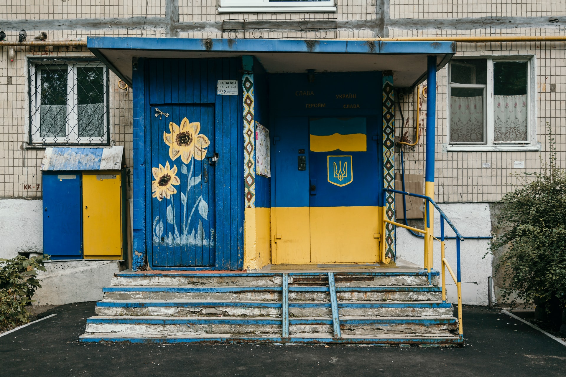 Entrance to a building painted with the Ukraine flag and sunflower motifs