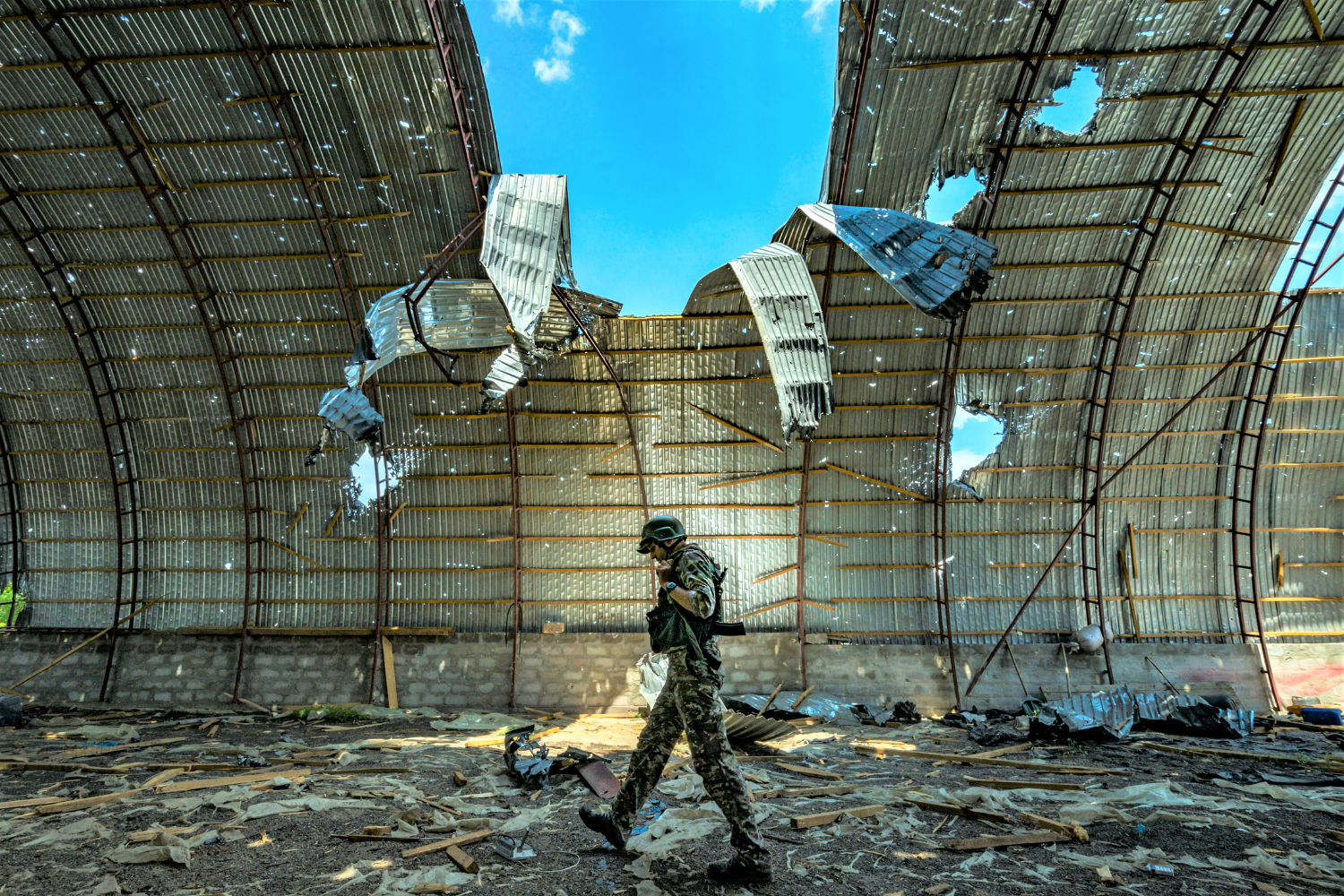 A Ukrainian soldier walks inside a barn destroyed by shelling, Zaporizhzhia province, Ukraine
