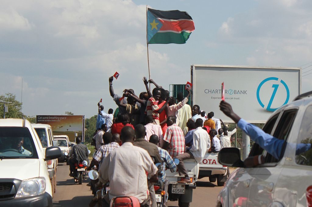 Ethnic group Ngok Dinka people celebrate with a South Sudanese flag in Juba on October 31, 2013, the results of an unofficial referendum of residents of contested region Abyei to decide if it lies in Sudan or South Sudan. Residents of Abyei chose overwhelmingly to join South Sudan, election officials said on October 31, amid warnings the poll could inflame tensions in the volatile region. The fate of Abyei is one of the most important and sensitive issues left unresolved since South Sudan became an independent state in 2011, ending two decades of civil war in Sudan. AFP PHOTO / WAAKHE SIMON (Photo by Simon Wudu WAAKHE / AFP) (Photo by SIMON WUDU WAAKHE/AFP via Getty Images)