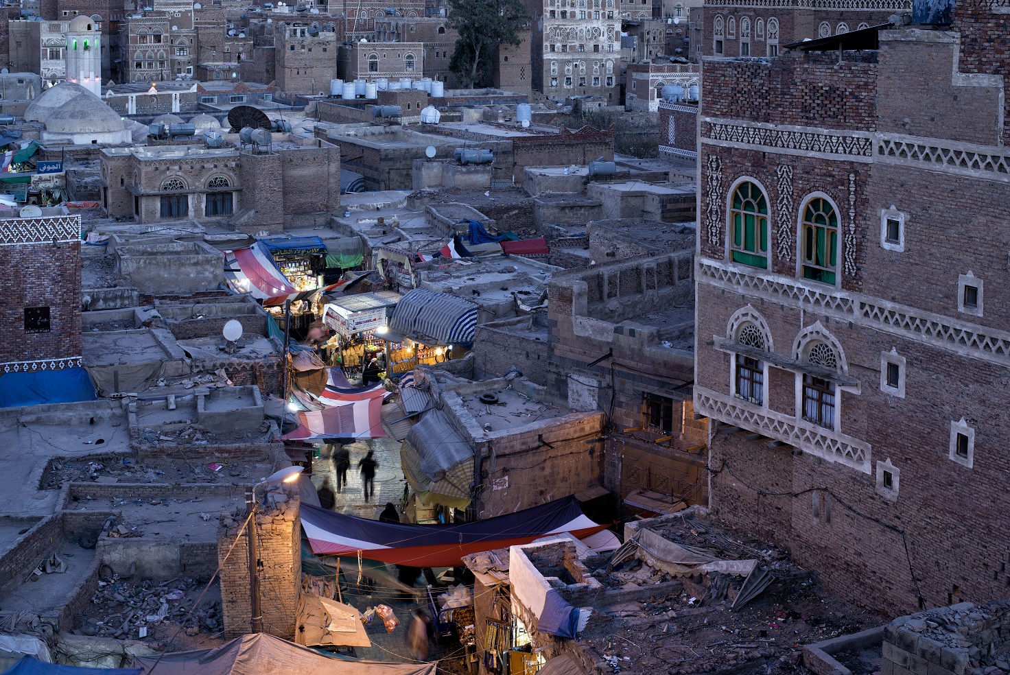 Overhead view of rooftops along a well-lit street in Sana'a, Yemen (2022).