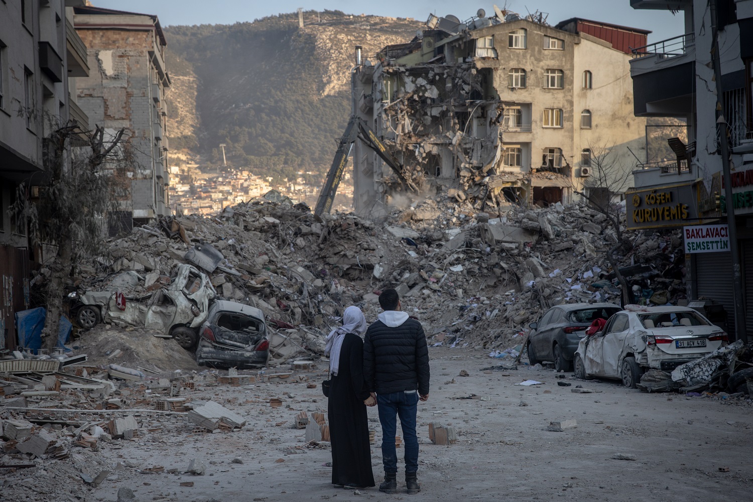 A couple look at destroyed buildings on February 19, 2023 in Hatay, Turkey.