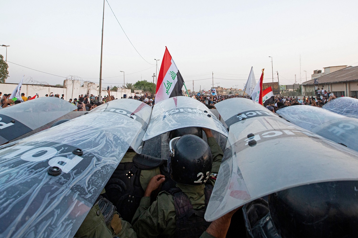 Iraqi security forces take position in a packed formation with shields during a rally protesting endemic corruption, in Basra, Iraq, October 2022. Photo by Hussein FALEH / AFP via Getty Images