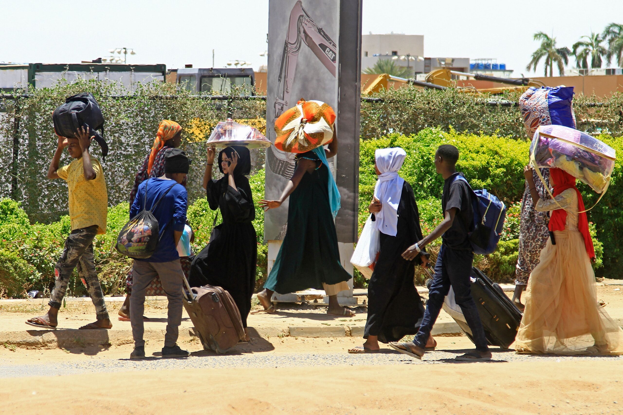 People carry baggage as the leave southern Khartoum on 18 April 2023, fleeing that conflict that broke out between the army and paramilitary forces on 15 April. Photo by AFP via Getty Images