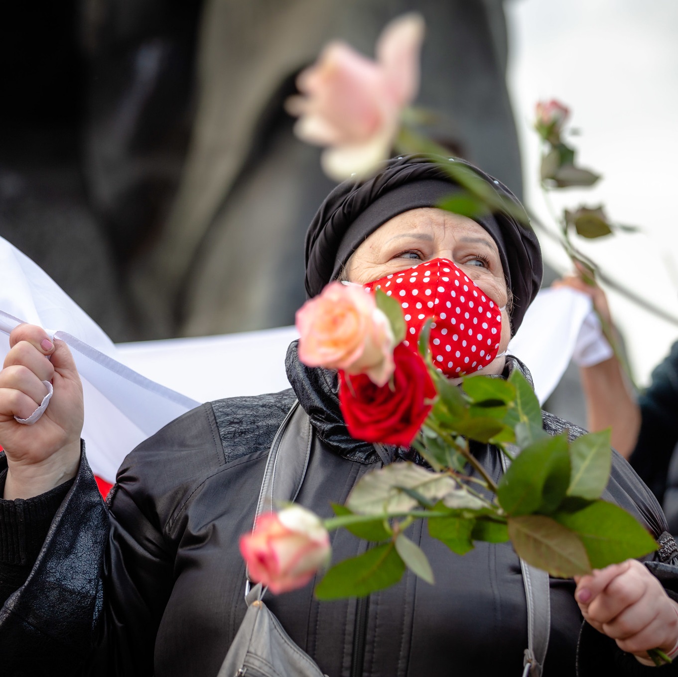 A protestor at a demonstration in Minsk wears a facemask and holds long-stem roses, 26 October 2020. Photo by Max Katz on Flickr (CC BY-SA 2.0)