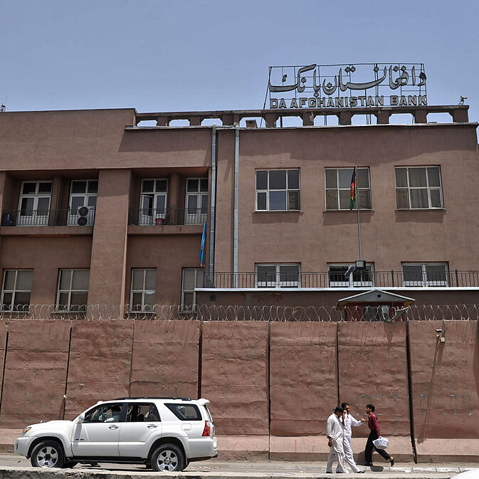 Afghan men walk past Da Afghanistan Bank in Kabul, Afghanistan on 28 June 2011.
