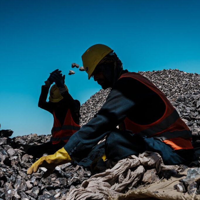Workers sort through crushed rocks containing chromite, a natural resource required for the production of stainless steel, at the Mughulkhil mine in Logar Province, Afghanistan, September 2022