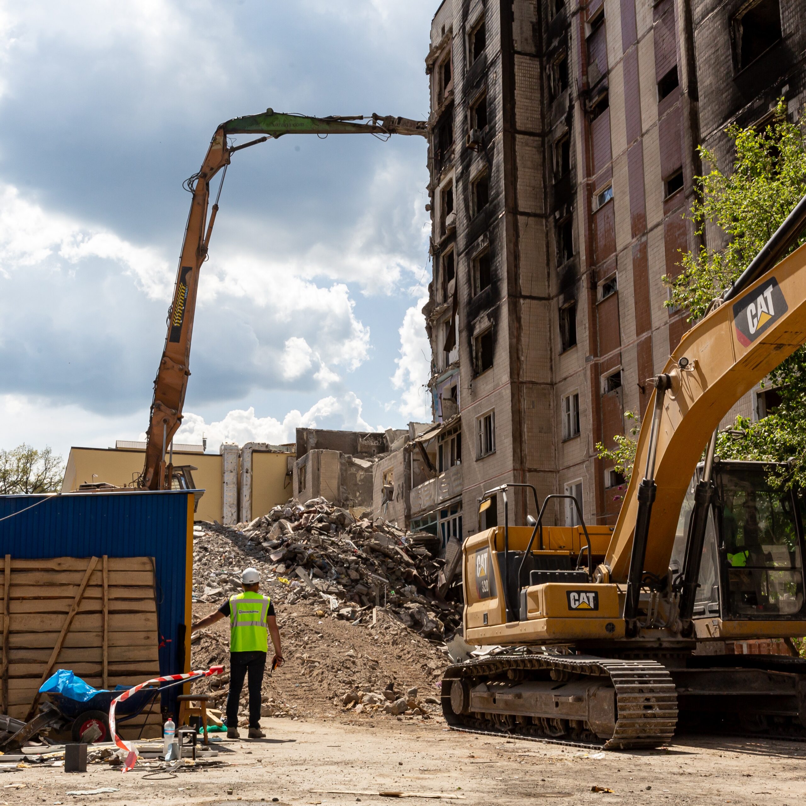 Construction workers watch as a block of flats that has been damaged by bombings is demolished in Irpin, Kyiv region, Ukraine on May 13, 2023. Photo by Dominika Zarzycka / NurPhoto via Getty Images
