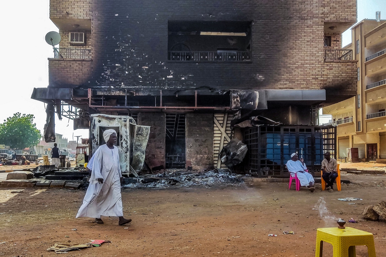 A man walks past a burnt out bank branch in southern Khartoum, Sudan, on 24 May 2023.