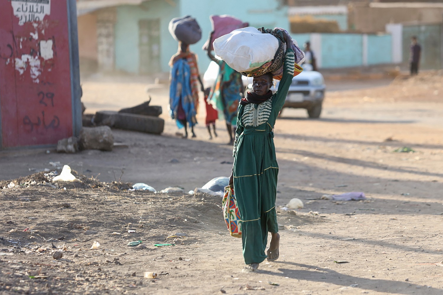 Women carrying bags and luggage are fleeing their neighbourhood in Khartoum on 19 April 2023