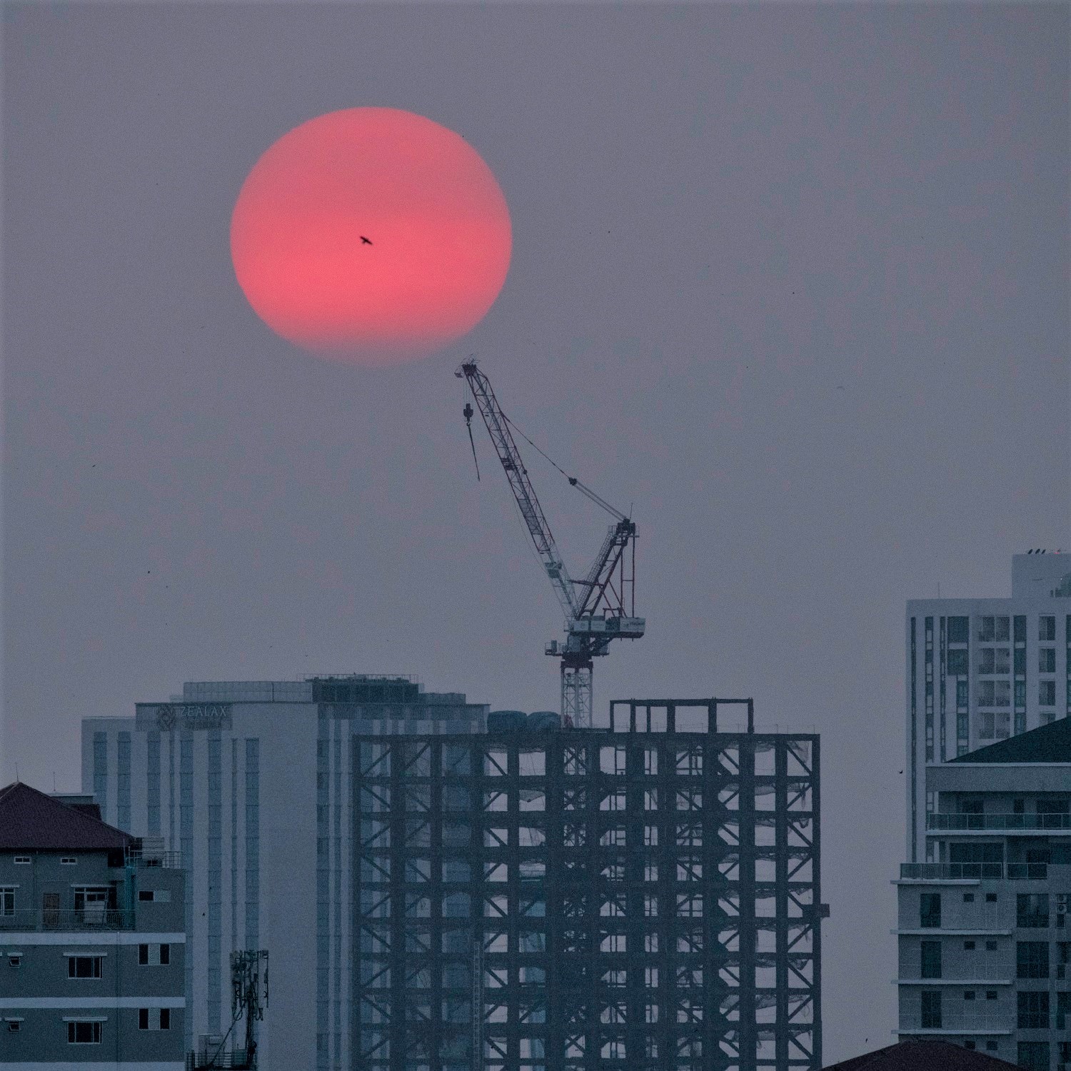 A view of a construction crane and the skyline of Yangon, Myanmar's capital, at sunset in May 2020