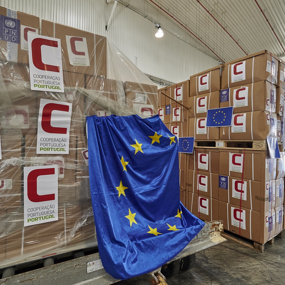 Boxes in humanitarian aid shipment are draped with a EU flag at a warehouse in Portugal, to be flown to Guinea-Bissau (July 2020)