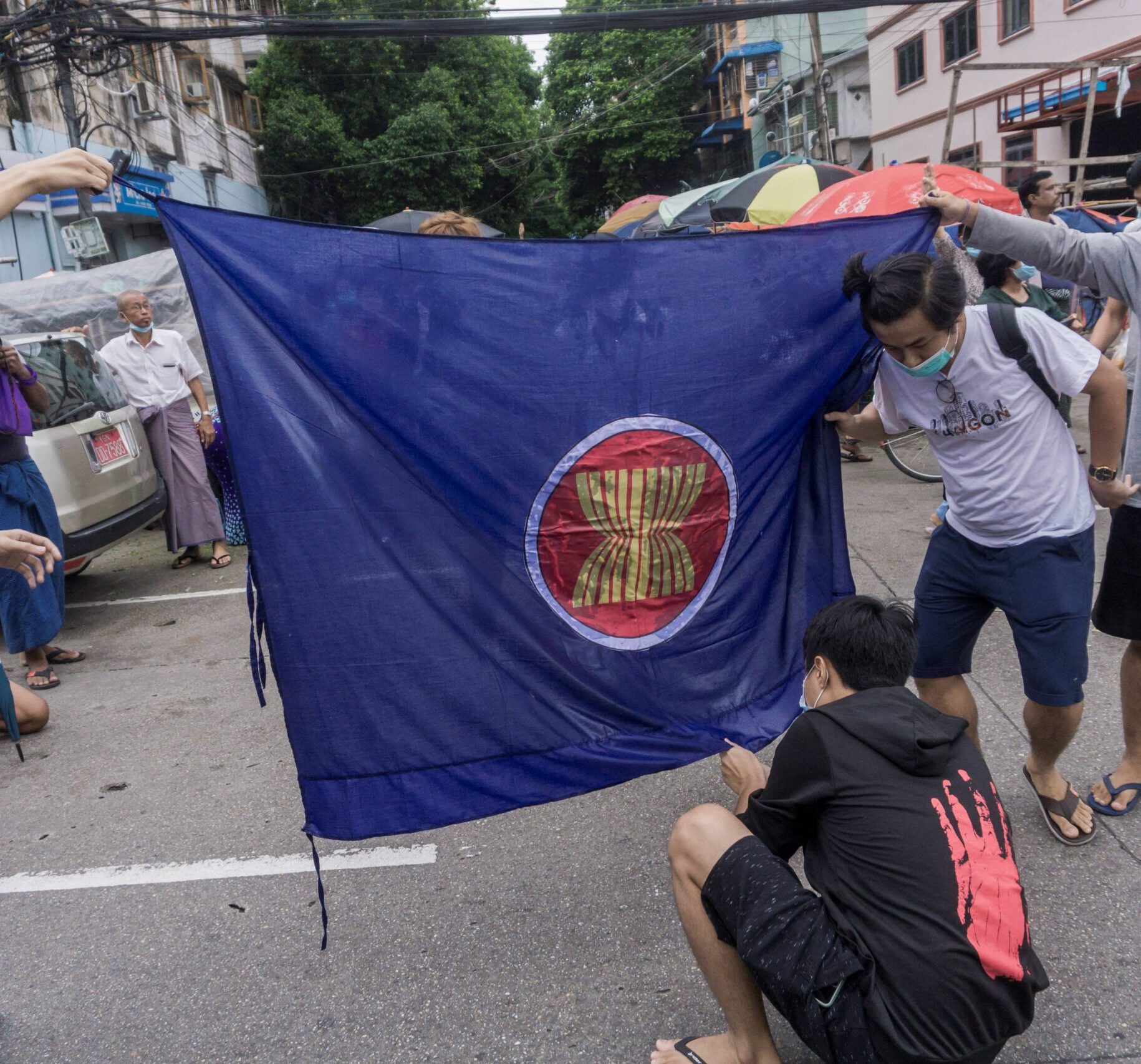 Protesters prepare to burn the flag of the Association of Southeast Asian Nations (ASEAN) grouping.
