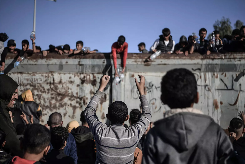 Palestinians rush to a truck carrying drinkable water in Rafah, southern Gaza, on 11 December 2023.