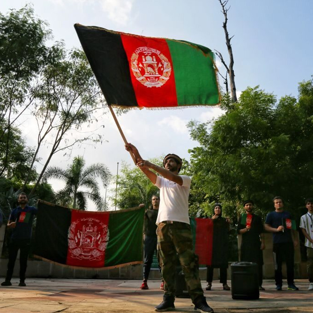 Man waves an Afghanistan flag at a peaceful protest against the Taliban in Dehli