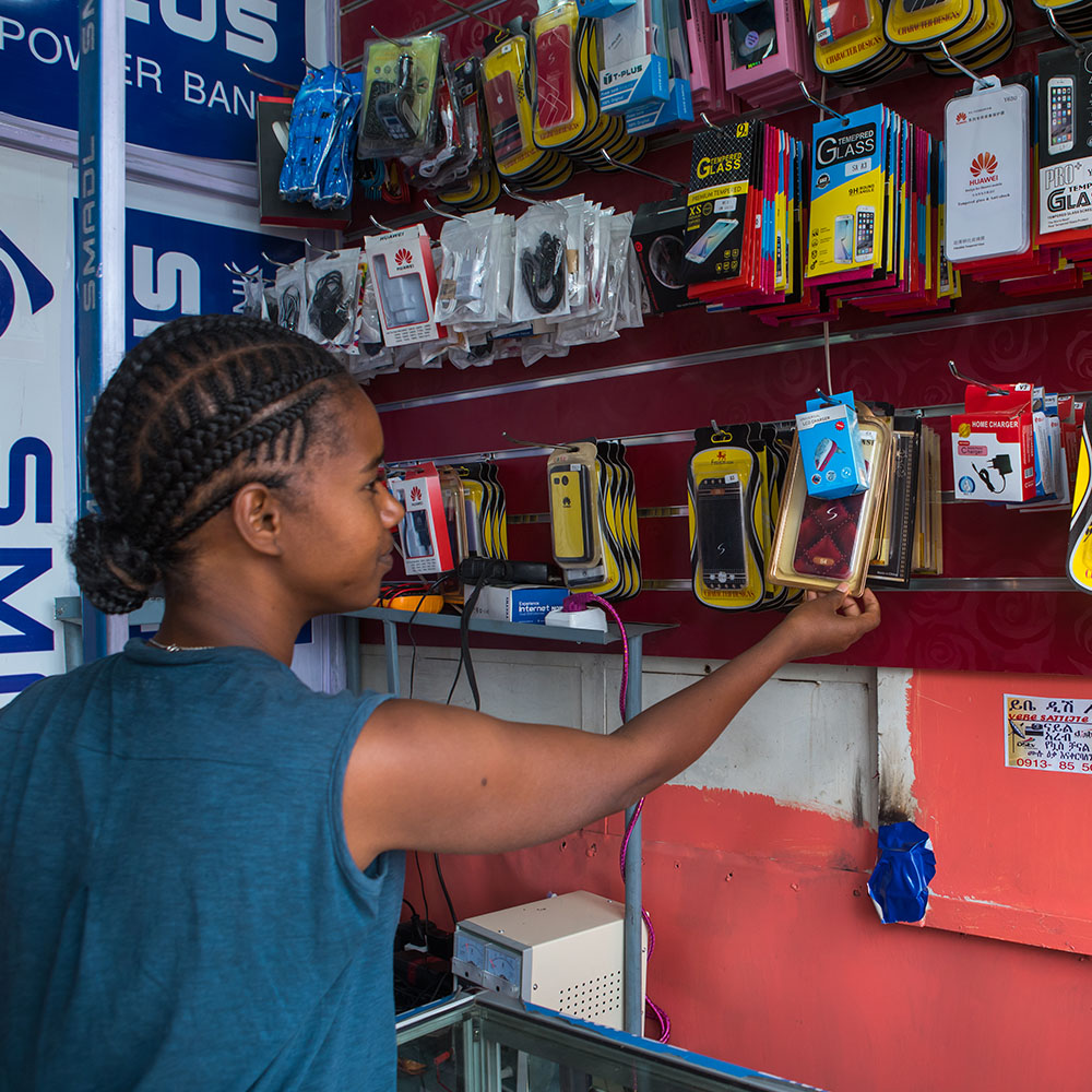 A girl chooses a phone in a shop in Addis Ababa