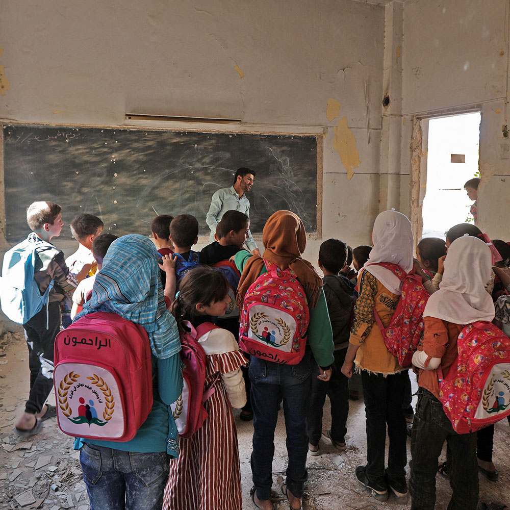 Syrian school children stand in a makeshift classroom