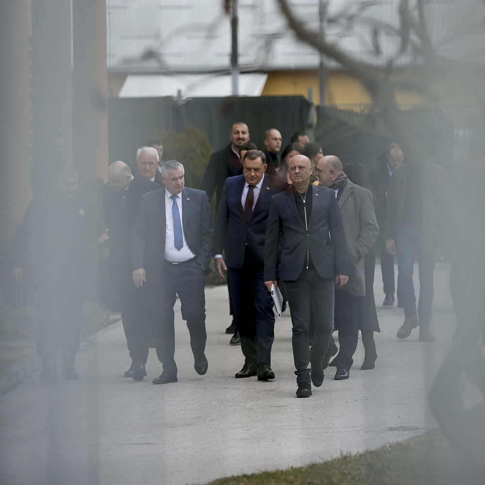 Bosnian Serb leader Milorad Dodik walks alongside lawyers outside a courthouse