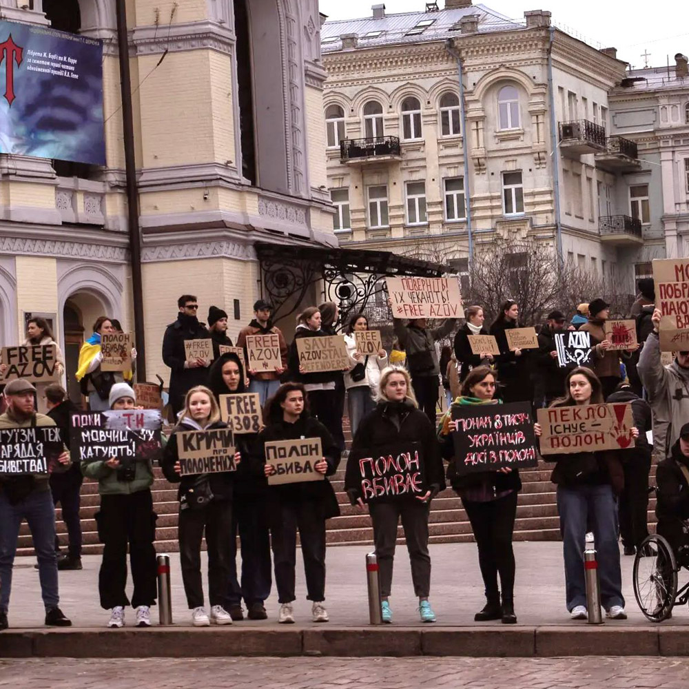 Protesters hold signs and gather to protest the war in Ukraine