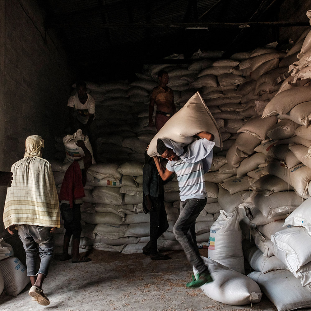 A man carries a sack of wheat over his head