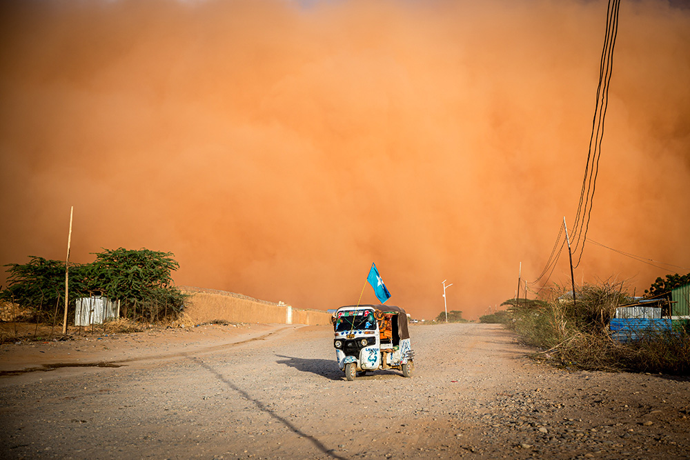 A tuktuk with a Somali flag drives during a sandstorm